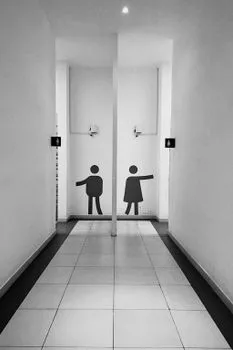 Minimalist black and white corridor with restroom signs in Almaty's public building.
